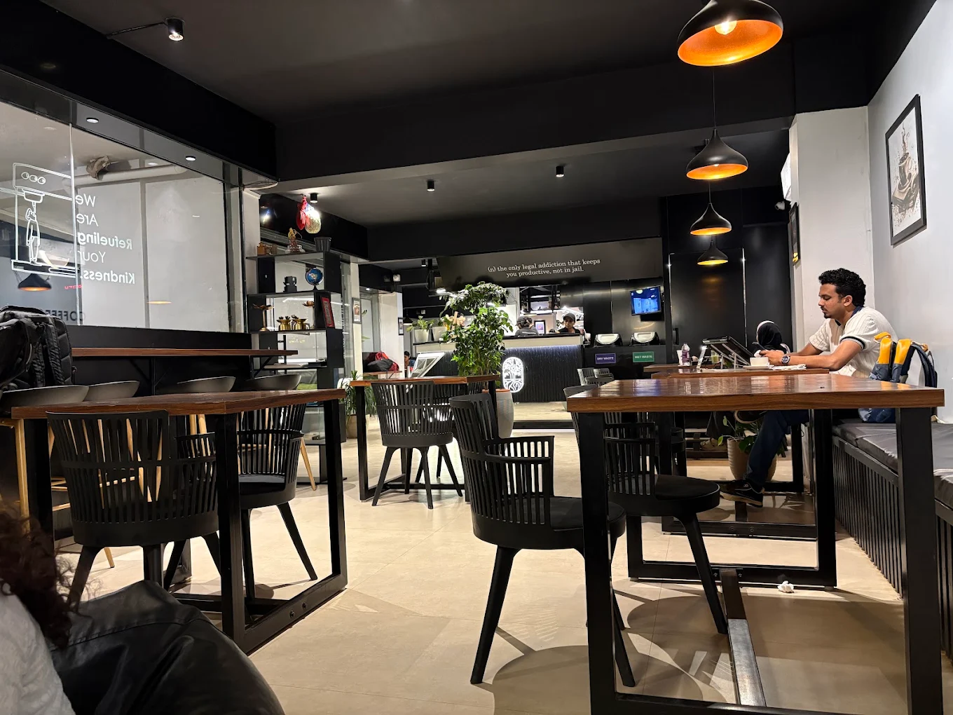 Inside Abrista café seating with pendant lights and the counter in the distance